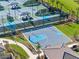 Aerial view of community basketball and tennis courts, manicured lawns, a walking path, and shade pavilions at 32707 Tamarind Grove Ln, Wesley Chapel, FL 33543