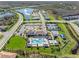 Aerial view of a community center featuring a pool, seating, well-manicured lawns, parking, tennis courts, and a playground at 32707 Tamarind Grove Ln, Wesley Chapel, FL 33543