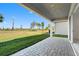 Covered patio with paver flooring that offers tranquil views of the manicured lawn and landscaping at 32707 Tamarind Grove Ln, Wesley Chapel, FL 33543
