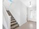 Bright foyer with tile flooring, stairway, and elegant front door with decorative glass at 32707 Tamarind Grove Ln, Wesley Chapel, FL 33543