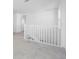 Bright hallway with white banister and plush gray carpet leading to the second floor and other rooms at 32707 Tamarind Grove Ln, Wesley Chapel, FL 33543