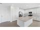 Modern kitchen boasting white cabinets, stainless steel appliances, a spacious island, and ample storage at 32707 Tamarind Grove Ln, Wesley Chapel, FL 33543