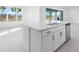 Kitchen island with stainless steel dishwasher, sink, white cabinets and granite countertops at 32707 Tamarind Grove Ln, Wesley Chapel, FL 33543