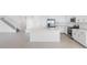 Open-concept kitchen featuring white cabinets, quartz countertops, stainless steel appliances, and island at 32707 Tamarind Grove Ln, Wesley Chapel, FL 33543