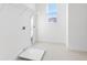 Well-lit laundry room with tile flooring, window and ample space for washer, dryer and storage at 32707 Tamarind Grove Ln, Wesley Chapel, FL 33543