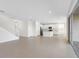 Spacious open-concept living area with tile floors, an island kitchen, and a staircase at 32707 Tamarind Grove Ln, Wesley Chapel, FL 33543