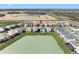 Aerial view showcases the backyard of homes overlooking a lake, set in a new residential community at 32707 Tamarind Grove Ln, Wesley Chapel, FL 33543