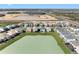 Aerial view showcases the backyard of homes overlooking a lake, set in a new residential community at 32707 Tamarind Grove Ln, Wesley Chapel, FL 33543