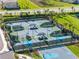 Aerial view of the community tennis and basketball courts, landscaped with palm trees, seating, and sidewalks at 32707 Tamarind Grove Ln, Wesley Chapel, FL 33543