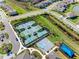 Aerial view of community tennis and basketball courts landscaped with sidewalks, lawns, palm trees, and shade pavilions at 32707 Tamarind Grove Ln, Wesley Chapel, FL 33543
