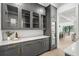 Stylish bar area with grey cabinetry, glass front cabinets, wine cooler, and marble backsplash at 5024 W Dickens Ave, Tampa, FL 33629