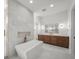 Elegant bathroom with marble wall, soaking tub, and double vanity with wood cabinets at 5024 W Dickens Ave, Tampa, FL 33629