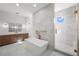 Bright bathroom featuring a soaking tub, walk-in shower, and double vanity with wood cabinets at 5024 W Dickens Ave, Tampa, FL 33629