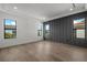 This bedroom has three large windows for natural light, wood floors, and a accent wall at 5024 W Dickens Ave, Tampa, FL 33629