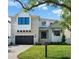 Beautiful two-story home with a manicured lawn, a brick driveway, and a black garage door underneath blue sky at 5024 W Dickens Ave, Tampa, FL 33629