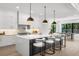 Modern kitchen with white cabinetry, a large island with seating, and pendant lighting fixtures at 5024 W Dickens Ave, Tampa, FL 33629