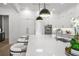 Bright kitchen with stainless steel appliances, a center island with bar stools, and modern lighting at 5024 W Dickens Ave, Tampa, FL 33629
