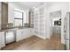 Well-appointed kitchen featuring white cabinetry, open shelving, stainless steel appliances, and a large window at 5024 W Dickens Ave, Tampa, FL 33629