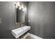 This powder room has a gray wall, gold fixtures, and a unique bowl sink design at 5024 W Dickens Ave, Tampa, FL 33629
