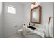 Modern powder room featuring a marble vanity with black basin sink, decorative mirror, and stylish lighting at 5024 W Dickens Ave, Tampa, FL 33629