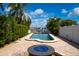 Inviting kidney-shaped pool with fire pit, surrounded by brick pavers and landscaping at 111 Driftwood Ln, Largo, FL 33770