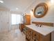 Bathroom with double vanity, storage cabinet, and large mirror at 111 Driftwood Ln, Largo, FL 33770