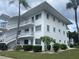 Two-story building with white exterior, featuring balconies and landscaping at 11201 80Th Ave # 201, Seminole, FL 33772