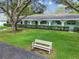 Exterior shot showing a row of condos with a bench, lawn, and large shade trees at 11200 102Nd Ave # 33, Seminole, FL 33778