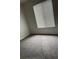 Simple carpeted bedroom with large window and closet at 2688 Pine Ridge N Way # D1, Palm Harbor, FL 34684