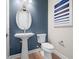 Powder room with pedestal sink, toilet, and blue accent wall at 4943 Ribbon Rock Cv, Lakewood Ranch, FL 34211