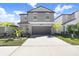 Two-story home with gray exterior, two-car garage, and landscaping at 16764 Delia St, Wimauma, FL 33598