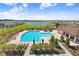 Community pool with surrounding landscaping and a playground at 16764 Delia St, Wimauma, FL 33598