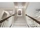 Modern staircase with white risers and dark wood railing at 5018 Sunnyside Ln, Bradenton, FL 34211