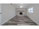 Spacious living room featuring a whitewashed brick fireplace and vinyl flooring at 1713 W Louisiana Ave, Tampa, FL 33603