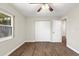 Bedroom showcasing wood-look floors, closet with white paneled doors, and a window at 5651 Wesson Rd, New Port Richey, FL 34655