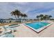 Community pool and spa with lounge chairs and palm trees at 690 Island Way # 812, Clearwater Beach, FL 33767