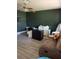 Living room with dark green walls, laminate flooring, and furniture at 5122 Lillilea Ln, New Port Richey, FL 34653