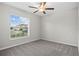 Clean bedroom featuring a ceiling fan, carpet flooring, and a window offering natural light at 12907 Wildflower Meadow Dr, Riverview, FL 33579