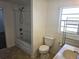 Bathroom featuring a shower-tub combo and a toilet next to a window at 5302 Turkey Creek Rd, Plant City, FL 33567