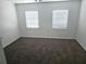 This cozy bedroom offers neutral walls, comfortable carpeting, and natural light from two windows at 5302 Turkey Creek Rd, Plant City, FL 33567