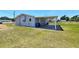View of the home's rear showcasing a covered patio and spacious yard at 5302 Turkey Creek Rd, Plant City, FL 33567