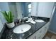 Bathroom with double vanity, granite countertop, and modern fixtures at 6203 N Flora Vista Ave, Tampa, FL 33604