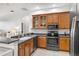 Modern kitchen features dark countertops, stainless steel appliances, and ample wood cabinetry at 10211 Cleghorn Dr, San Antonio, FL 33576