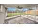 Spacious screened porch with grey flooring and ceiling fan at 3510 Allandale Dr, Holiday, FL 34691
