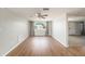 Living room with wood-look floors, ceiling fan, and large window providing natural light at 3510 Allandale Dr, Holiday, FL 34691