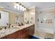 Double vanity bathroom with granite countertop and a bathtub at 18593 Bridle Club Dr, Tampa, FL 33647