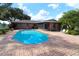 Inviting kidney-shaped pool with brick patio and surrounding landscaping at 5302 Turkey Creek Rd, Plant City, FL 33567