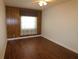Bedroom with wood-paneled accent wall and dark laminate flooring at 5302 Turkey Creek Rd, Plant City, FL 33567
