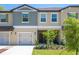 Tan and gray two-story townhome with two-car garage and small front yard at 17399 Nectar Flume Dr, Land O Lakes, FL 34638