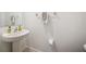 Small half bathroom with pedestal sink and toilet at 17399 Nectar Flume Dr, Land O Lakes, FL 34638